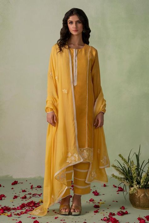 Mustard kurta with resham, thread, cutdana embroidery in floral placement pattern on border. Paired with lace detailed pant and dupatta. Components: 3 Pattern: Embroidered Type Of Work: Resham, thread, cutdana Neckline: Round Sleeve Type: Full sleeves Fabric: Kurta and Pant: Cambric Cotton Lined With Mul Cotton, Dupatta: Organza Color: Yellow Other Details:  Lace embroidered panel Sheer embroidered dupatta Kurta Length: 40 inches Approx. product weight: 1000-1500 gms Model height: 5ft 4inches, w Silk Kurti Designs, Kaftan Designs, Anarkali Dress Pattern, Long Kurti Designs, Kurta Neck Design, Palazzo Set, Kurta Designs Women, Yellow Silk, Designer Party Wear Dresses