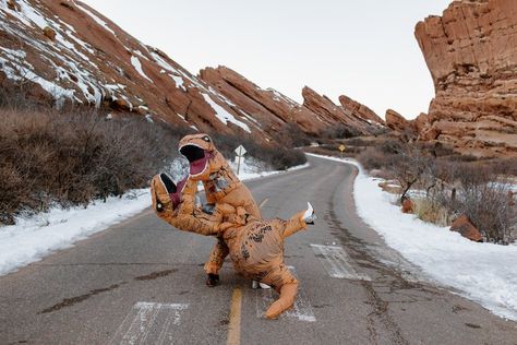 Dinosaur Photoshoot, Dinosaur Wedding Theme, Red Rocks Colorado, Dinosaur Wedding, Inflatable Dinosaur Costume, Themed Engagement Photos, Inflatable Dinosaur, Cute Couples Costumes, Dino Costume