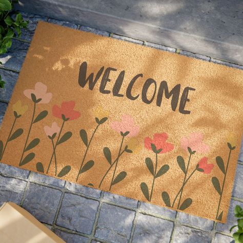 Welcome to our charming floral welcome mat, the perfect addition to your entryway! Crafted with care, this delightful mat features a vibrant array of blooming flowers that greet your guests with warmth and elegance.  Whether you're adding a touch of nature to your home or looking for a thoughtful gift, this floral welcome mat is sure to bring a smile to every visitor's face. Each custom mat comes in a 24" x 16" size and is made with Grade A tufted coir coconut fiber, making it perfect for outdoor use. All mats feature black vinyl backing for increased stability. .: One size: 24" × 16" (61cm x 40.6cm) .: Material: Grade A tufted coir coconut fiber .: Black vinyl backing .: Mainly for outdoor use .: Assembled in the USA from globally sourced parts Painted Door Mat, Diy Welcome Mat, Cute Door Mats, Door Mat Funny, Front Door Mat, Front Door Mats, Custom Mats, Funny Doormats, Coconut Fiber