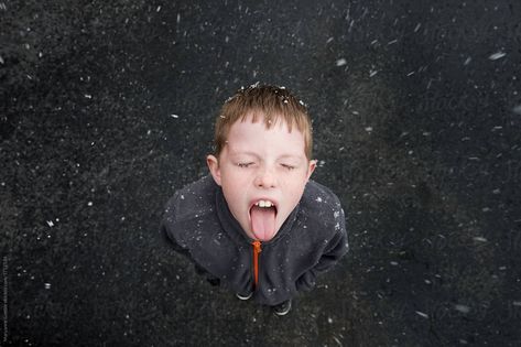 An adorable young boy closes his eyes and sticks out his tongue to catch the falling snow on a winter day as seen from above. Catching Snowflakes On Tongue, Christmas Through The Eyes Of A Child, Young Snow, Sticking Tongue Out, Catching Snowflakes, Angry Child, Snow Fall, Falling Snow, Child Rearing