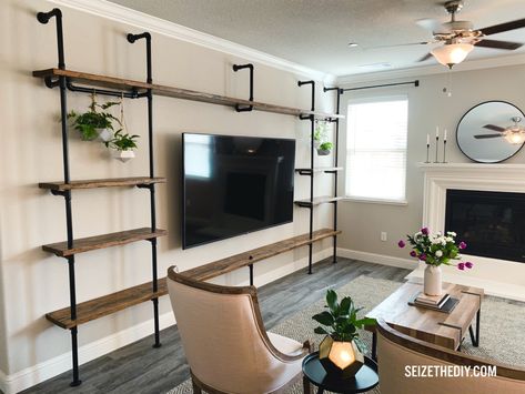 Industrial-inspired built-in entertainment center with hanging geometric planters, distressed and stained Doug Fir wood, by Emil Sandman / Seize The DIY. #pipeshelf #industrial #home #homedecor #interior #design #interiordesign #diy #furniture #tv #media #entertainmentcenter #mediawall #shelf #custom #hanging #plants #industrial #industrial #tv #tvstand #console #mediastand #stand #decor #industrialshelf #home #planter #hangingplants #rustic #modern #wood #metal #woodandmetal Industrial Pipe Tv Stand, Industrial Media Wall, Industrial Shelves Living Room, Townhouse Upgrades, Bookshelf Entertainment Center, Industrial Entertainment Center, Diy Pipe Shelves, Industrial Wall Shelves, Wall Shelves Living Room