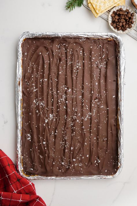 christmas crack ingredients on baking sheet with sea salt Christmas Crackle Candy, Cracker Bark Saltine, Easy Saltine Cracker Candy, Cracker Candy With Saltines, Candy Made With Saltine Crackers, Saltine Toffee, Homemade Toffee, Microwave Fudge, Saltine Crackers