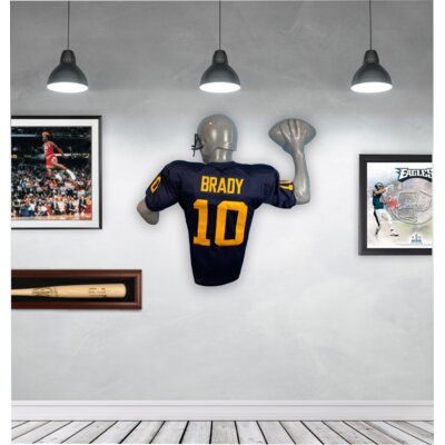 Bring your favorite Quarterback's jersey to life. It will be the first thing guests notice when they walk into your room. Display your favorite professional, college or high school jersey. Our displays are made of a lightweight, durable plastic that hangs flat on the wall with just 2 screws. Simple assembly allows you to easily fit and hang your favorite jersey. Fits adult jersey sizes M-XXL. | Jerzee Art Football Quarterback Jersey Case, Size 42.0 H x 36.0 W x 7.0 D in | Wayfair Sports Tickets Display, Game Room Tv Wall Ideas, Man Cave Tv Wall, Sports Jersey Display, Sports Memorabilia Display, Memorabilia Wall, Ticket Display, Jersey Fits, Jersey Display Case