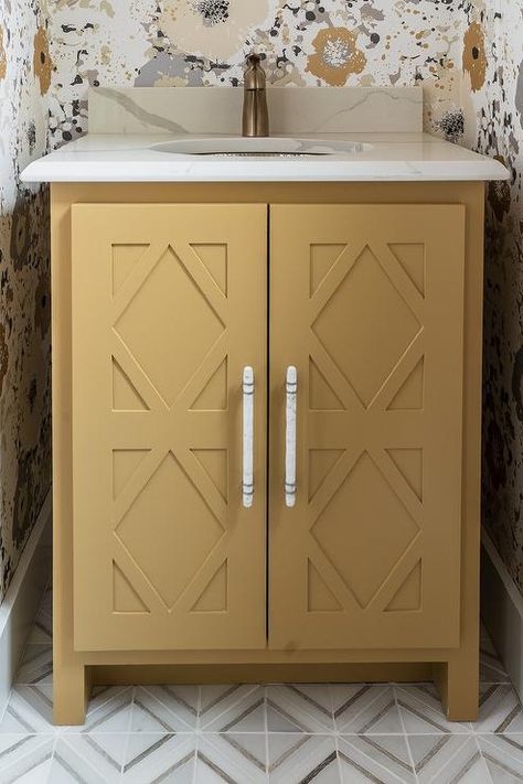 Charming yellow and gray powder room features a mustard yellow washstand placed on white and gray marble diamond pattern floor tiles and accented with diamond doors and a marble-like quartz countertop. Mustard Yellow Powder Room, Yellow Bathroom Vanity, Small Powder Room Wallpaper Mustard, Gray Powder Room, Mustard And Grey Wallpaper, Yellow Tile Bathroom Wallpaper, Pattern Floor Tiles, Floating Sink Vanity, Vintage Yellow Bathroom Tile With Wallpaper