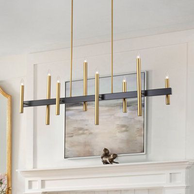 Simple and elegant, this linear chandelier features a sturdy metal frame in brushed gold and matte black finish. Two downrods suspend from the rectangular canopy to fix seamlessly with the lamp body, which features a clean-lined supporting base with 8 asymmetric candle-like arms in diverse sizes, which is a renovation of the traditional one. Plus, with no lampshades, it allows you to showcase your choice of bulbs. Finish: Matte Black/Gold | Mercer41 Trivon 8 - Light Dimmable Linear Kitchen Islan Rectangle Table Light Fixture, Linear Pendants Over Kitchen Island, Lighting Over Rectangle Dining Table, Long Dining Room Chandelier, Brass And Black Pendant Light, Linear Chandelier Dining Room Modern, Modern Rustic Light Fixtures, Black And Gold Kitchen Lighting, Black And Gold Chandelier Dining Room