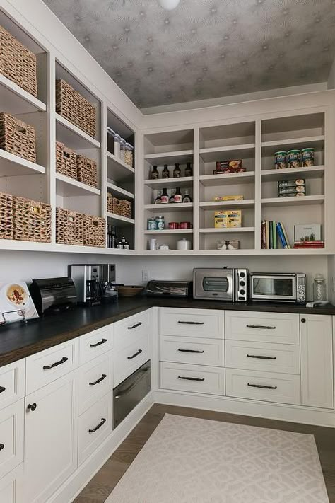 Well stocked l-shaped kitchen pantry features a gray trellis rug complementing off-white shaker cabinets finished with oil rubbed bronze hardware and an under counter warming drawer fixed beneath an oak wood countertop. Ultimate Pantry, Walk In Pantry Ideas, Traditional Kitchen Cabinets, Pantry Layout, Pantry Decor, Farmhouse Pantry, Pantry Room, Pantry Remodel, Pantry Shelving