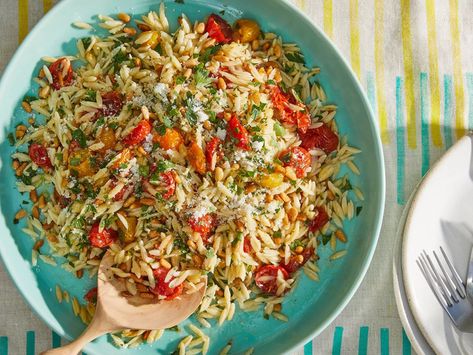 Swipe right on this clever pasta salad, which combines rice-sized grains of orzo with a cornucopia of delicious flavors—Dijon, honey, and Parmesan all come to the party, thank you very much—with roasted cherry tomatoes, which transform into juicy umami orbs after an hour in the oven. Pine nuts are a worthy splurge in this creative recipe, but you can substitute toasted almonds or walnuts. Enjoy al fresco on a hot summer day with a glass of white wine and a big enough bowl for the heaping portion Orzo Tomato, Picnic Menu, How To Cook Orzo, Easter Side Dishes, Tomato Salad Recipes, Orzo Recipes, Roasted Cherry, Orzo Salad, Roasted Cherry Tomatoes