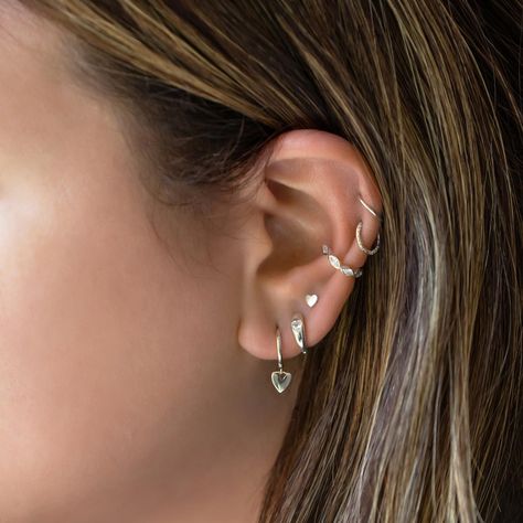 These earrings feature shimmering hearts polished to a high shine, elegantly dangling from classic hoops. Perfect for adding a touch of romance to any look.Sterling Silver Height 20mm(0.8in) x Width 6.5mm(0.25in) Inside diameter: 9mm #E458-S Ear Styling Ideas Silver, Conch Piercing Hoop Silver, Silver Ear Piercing Ideas, Silver Ear Piercing Stack, Silver Piercing Stack, Silver Earring Stack 3 Holes, Ear Stack Silver, Silver Stacked Earrings, Silver Earrings Stack