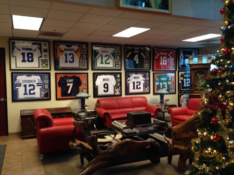 Loyal customer with one of the most impressive framed jersey collections you'll ever see! One wall dedicated just to QBs! #manning #staubach #warner #elway #namath #brees #favre #brady #montana #marino #aikman #rodgers #roethlisberger #quarterback Framed Jerseys On Wall Basement, T Shirt Display Ideas Frames, Framed Jerseys On Wall, Jersey Display Ideas, Loft Remodel, Gentlemans Lounge, Small Bars For Home, Sports Man Cave, Jersey Display Case