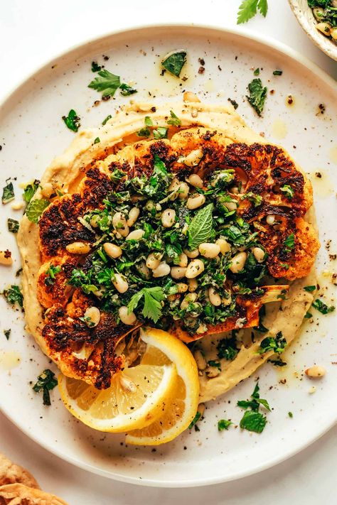 Zesty cauliflower steaks are served over hummus and sprinkled with a lemon-mint pine nut gremolata. A simple, healthy and absolutely delicious dinner recipe that also happens to be vegetarian, vegan and gluten-free. | gimmesomeoven.com Vegeterian Dishes, Veggie Mains, Cauliflower Steak, Roasted Cauliflower Steaks, Main Recipes, Meat Meals, Pasta Meals, Gimme Some Oven, Cauliflower Steaks