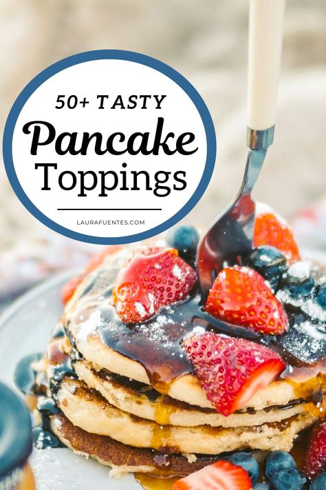 A stack of pancakes with strawberries, blueberries, syrup and powdered sugar