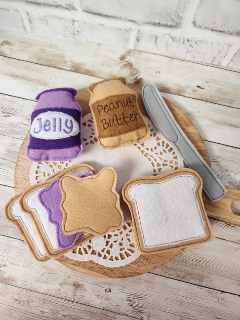 Let's make a sandwich!  Your Little is going to have a ton of fun playing and learning with this Peanut Butter and Jelly Jar Pretend Play Food set! It's a wonderful alternative to hard plastic play food. The full set includes 1 felt jelly jar, 1 felt Peanut Butter jar, 1 felt knife, and the option of one or two sandwiches. The jars only option will come with both jars and the knife.  Each one made from safe and soft felt fabrics. The details are embroidered using an embroidery  felt jars measure Make A Sandwich, Embroidery Felt, Felt Toys Diy, Felt Food Diy, Felt Food Patterns, Peanut Butter Jar, Play Food Set, Pretend Play Food, Felt Play Food