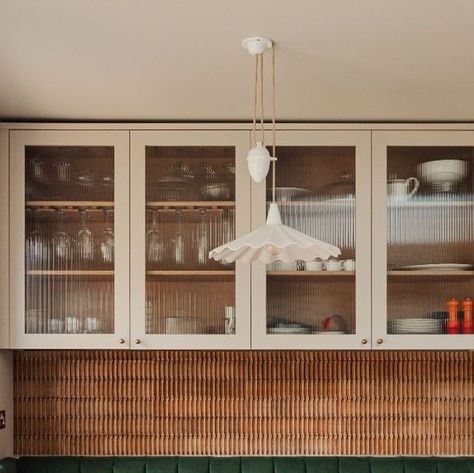 Victoria Newall on Instagram: "The Dining nook of this kitchen/diner/snug : An opportunity to add some colour and texture into this hard working family space. Vintage cigar presses are set into the recess over the banquette, the linear texture is continued in the reeded glass cabinets. All set off but this beautiful bone china rise & fall pendant by @originalbtc #interiors #interiordesign #interiordesigninspiration #interiordesigners #pendantlights #interiordesigninspo #interiorstyling #interi Reeded Glass Kitchen Cabinets, Reeded Glass Cabinets, Textured Glass Kitchen Cabinets, Reed Glass Kitchen Cabinets, Reeded Glass Cabinet, Dining Booths In Homes, Reeded Glass Kitchen, Minimal White Kitchen, White Cupboard