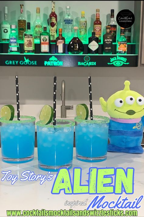 This image shows three blue drinks with lime green rims with black star straws and a lime wheel granish with a Toy Story Alien plush in front of a home bar. Toy Story Alien Party, Toy Story Themed Dinner, Pizza Planet Party Ideas, Toy Story Movie Night, Toy Story Alcohol Drinks, Toy Story Inspired Food, Alien Themed Cocktails, Toy Story Drinks, Alien Alcoholic Drinks