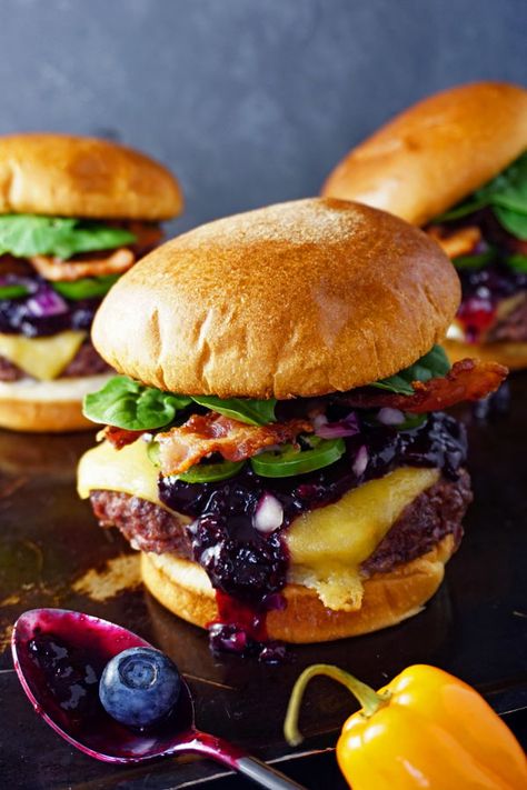 Turn up the heat on your next burger night with these juicy bacon cheeseburgers topped melty gouda cheese and a sweet, yet spicy, habanero-lime blueberry compote. Garnished with fresh jalapeños, diced red onion and baby spinach, these burgers are bursting with color and flavor.  #burger #cheeseburger #habanero #grillingrecipes #blueberry #recipe Black And Blue Burger Recipe, Bobs Burgers Recipes, Specialty Burgers, Black And Bleu Burgers, Bacon Blue Cheese Burger, Lime Blueberry, Mediterranean Burger, Bacon Bleu Cheese Burger, Blueberry Recipe