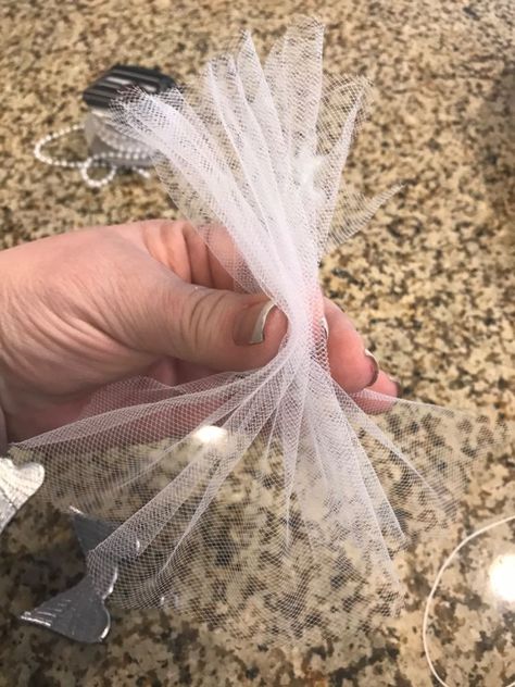 Hey Hometalk! If you're looking for a Christmas ornament idea that is super easy to make, this one is for you! I love angels and this one will be put on my tree.        First take some tulle and fold it like an accordion. Then tie a string at the top. You can use some scissors to straighten out the edges.    The next thing I did was cut a cap off of the ornament.    Then I glued the cap to a wooden bead.    It'll look like this!    Then glued the white bead to the top- it's the angel… Angels Made With Tulle, Tulle Christmas Angels, Angel Ornaments From Ties, Angels To Make For Christmas, Diy Tulle Angel Ornaments, No Sew Angel Ornament, Easy Angels To Make, Easy Angel Ornaments To Make, Christmas Diy Angles