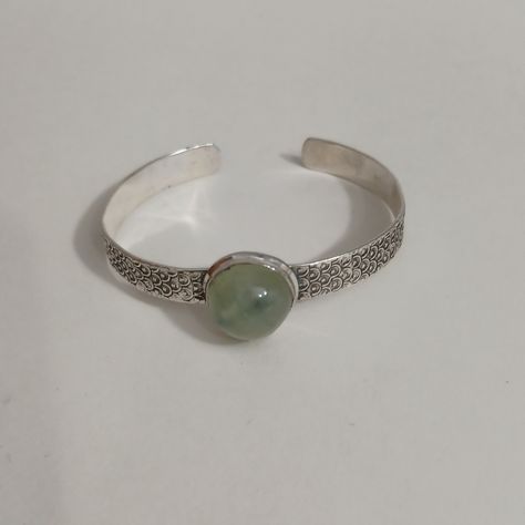 Prehnite Round Silver Slim Cuff Bracelet Is Uniquely Graceful Collectable Cuff Bracelet. In The Center Of The Bracelet Is A Round Prehnite Gemstone. It's 1.0 Inches High And 1.0 Inches Wide. The Cuff Has A Textured Fish Scale Like Design. The Cuff Fits Wrist Sizes 7.0, 7.5, And 8.0 Inches. Quality Sterling Silver Plated The 92.5 Sterling Silver Stamp Is Present On The Inner Cuff Of The Bracelet. Just A Great Versatile Neutral Soft Green Bracelet, That Makes A Great Gift Anytime Of The Year. Gems Balance Aura, Fish Bracelet, Silversmith Jewellery, Three Necklaces, Fishing Bracelet, Green Bracelet, Gems Bracelet, Fish Scale, Sterling Silver Cuff Bracelet