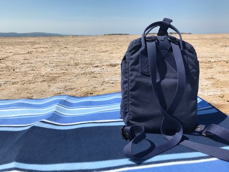 Fjallraven Re-Kanken Mini on a blue picnic blanket on the beach in North West England. Re Kanken, Blue Picnic, Kanken Mini, West England, Backpack Organization, Backpack Reviews, Blue Backpack, Small Backpack, Mini Backpack