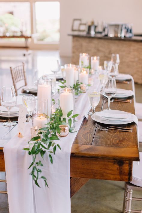 Simple elegant farm table runner idea  - Italian ruscus and candles. Table Runner And Candles, Italian Ruscus Garland With Bud Vases, Loose Greens On Table Wedding, Italian Ruscus Table Runner, Ruscus Table Runner, Italian Ruscus Wedding, Italian Ruscus Garland, Farm Table Runner, Rectangle Wedding Tables