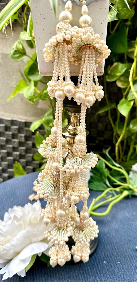 Silver Gota & Pearl Crystal Cut Dana Multi-String Hanging Latkan - 1 Pair ✨ Add a touch of elegance to your bridal attire with our silver gota and pearl crystal cut dana latkans. Featuring a multi-string design, these hanging tassels are perfect for enhancing lehengas, dupattas, blouses, and waist belts 💍🌟. Materials: Silver Gota 🌟 Pearl Crystals 💎 Cut Dana ✨ Multi-String Design 🎀 Uses: Bridal Lehenga: Ideal for adding intricate and sophisticated details to lehengas. Dupatta Embellishment: Perfect for decorating dupattas with a luxurious finish 🪡. Blouses & Waist Belts: Enhances blouses and waist belts with traditional charm. DIY Projects: Versatile for various crafting and embellishment projects 🎨. Sold by the pair, these high-quality latkans are designed to elevate your outfits an Bridal Indian, Indian Bride Outfits, Pearl Crystal, Bride Clothes, Silver Crystal, Bridal Lehenga, Wedding Basket, Bead Weaving, Indian Bride