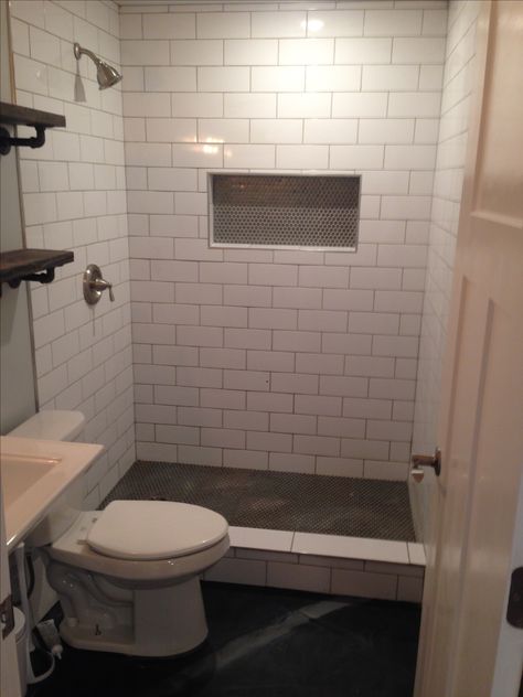 Large tile subway, niche & shower floor metallic penny, stained concrete floor Concrete Shower Floor, Stained Concrete Floor, Concrete Shower, Concrete Stained Floors, Beach Bathroom, Large Tile, White Subway Tile, Concrete Floor, Bathroom Reno