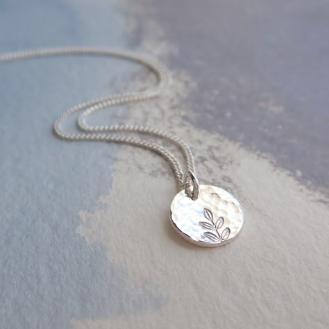 Our delicate Silver Hammered Disc Necklace is 925 Sterling Silver. The tiny silver disc has been gently hammered giving it an interesting texture that reflects the light beautifully. The disc pendant has been hand stamped with a tiny leaf print - a perfect gift for a nature lover! Details: * Necklace length 18'' * The fine curb chain is sterling silver * The tiny disc pendant measures approx. 9mm Your silver disc necklace will arrive carefully packaged and presented in a Silver Willow gift box, making it a perfect gift for a loved one or a special treat for yourself. Matching Silver Disc Earrings available: https://www.etsy.com/uk/listing/1250063904/hammered-silver-earrings See more Jewellery from SilverWillowUK: https://www.etsy.com/uk/shop/SilverWillowUK Thank you for looking! Silver Pendant Necklace Simple, Metal Stamped Necklace, Tiny Pendant Necklace, Silver Layered Necklace, Jewellery Workshop, Pmc Jewelry, Art Clay Silver, Wood Jewelery, Silver Metal Clay