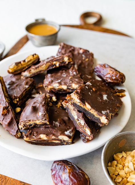 This viral date bark recipe combines medjool dates with peanut butter, chocolate and peanuts. It tastes like a Snickers bar and is the perfect healthy treat to keep stocked in your freezer. Vegan + gluten-free. Peanut Date Bar, Dates With Peanut Butter, Heathy Sweets, Peanut Butter Chocolate Bark, Heathly Snacks, Snickers Slice, Dates Recipes, Healthier Treats, Cookie Stand