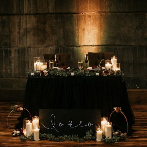 Romantic and elegant sweetheart table setup photo by The Gowans @oliopeabody ✨Modern/industrial event space Flexible: weddings, social, corporate, more 🏆Best Of Boston 🖤 Mother/daughter team 📍Historic downtown Peabody #industrialwedding #bostonwedding #weddingvenue Sweetheart Table Wedding Dark And Moody, Goth Bride And Groom Table, Sweetheart Table Black Tablecloth, Dark Sweetheart Table, Dark Romantic Sweetheart Table, Gothic Sweetheart Table, Art Deco Sweetheart Table, Dark And Moody Sweetheart Table, Moody Sweetheart Table Wedding