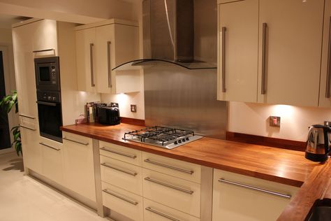 Cream Gloss Kitchen. Stainless steel splash back and walnut work top and upstand Cream And Wood Kitchen, Cream Gloss Kitchen, Gloss Kitchen, Cream Kitchen, Kitchen Renovations, Cabinet Makeover, Kitchen Worktop, Kitchen Plans, Kitchen Diner