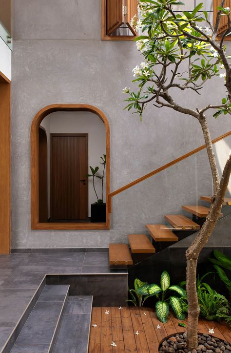 With earthy tones, lush pocket gardens, and luminous skylights, this beachside home by Studio Context is an ode to the coastline. Staircase With Courtyard Design, Unique Elevation Design, House Landscape Plan, Tropical Residence, Tropical Houses Interior, Earthy Homes, Modern Skylights, Creative Doors, Tropical Houses Architecture