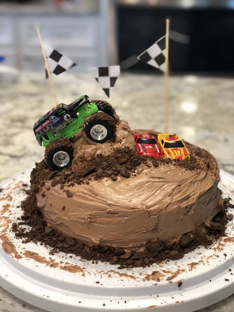 Monster truck cake. Used a hot dog bun cut in half to make ramp, and crushed chocolate graham crackers for dirt. For the banner I used wooden skewers and glued cut out scrapbook paper to string. Ran the truck tires through frosting to add tire mark effects. Festa Monster Truck, Monster Truck Birthday Cake, Truck Cupcakes, Monster Jam Birthday, Monster Jam Party, Hot Dog Bun, Truck Birthday Cakes, Wooden Skewers, Truck Cake