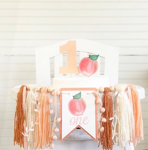 "*Please check turn around times. All items are made to order* Our high chair yarn banner is super cute for any little one's birthday party! Would also work great as a backdrop for cake smash photos.  Made with yarn tassels in peach, dark peach, and ivory. Comes with peach \"One\" pennant.   Measures approximately 17 inches wide  and tassels are approximately 7 inches long.  Drapes across front of high chair.    Cardstock cake topper measures approximately 4.5\" and 3\" for each piece.  Can do c Pink And Peach Party, Sweet Peach First Birthday Party, Peach Themed 1st Birthday Party, Peachy One Birthday, First Birthday Peaches Theme, 1st Birthday Peach Theme, Peach One Year Birthday, One Sweet Peach Birthday Cake, Sweet As A Peach First Birthday