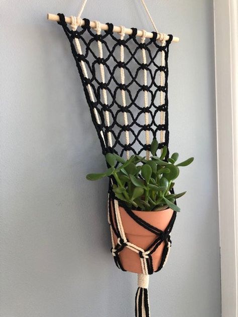 This lovely macrame plant hanger is great in any home. Since you can hang it up on your wall there is no need to drill up in your ceiling. This wall hanging macrame plant hanger is hand made. It is hung from a 12 inch dowel rod and it was made with 132 feet of 4mm, 3 ply cotton cord. It hangs 38 inches from the top of the hanging cord, and the pot sits at about 27 inches. It fits a 5 to 6 inch pot. Potted plant is not included. Small Macrame Plant Hanger, Macrame Wall Plant Hanger, Diy Macrame Plant Hanger Easy, Macrame Crafts, Plant Hanger Macrame, Wall Plant Hanger, Macrame Plant Hanger Patterns, Macrame Planter, Macrame Knots Tutorial