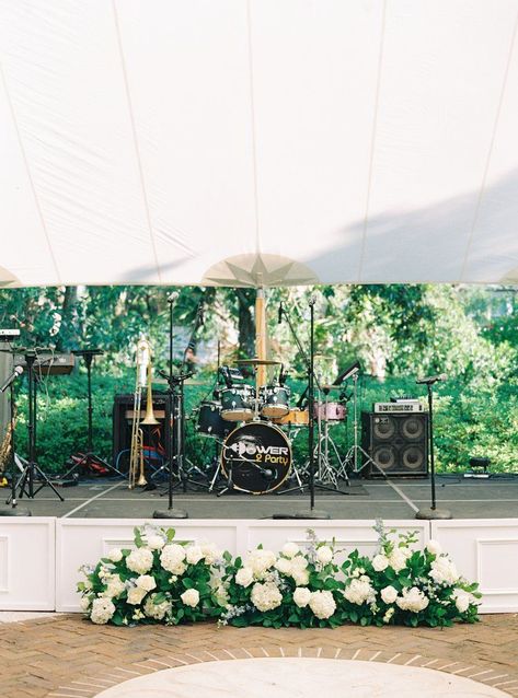 White stage wedding band set up with flowers. Power 2 Party wedding band. Charleston wedding photographer. Live Band Wedding Stage, Flowers In Front Of Band Wedding, Wedding Live Band Set Up, Stage Flowers Wedding, Wedding Band Stage Flowers, Tent Wedding Florals, Wedding Stage Flowers, Wedding Band Stage Decor, Band Stage Wedding