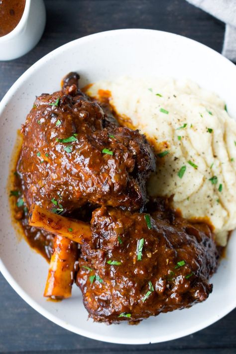 These slow cooked braised lamb shanks are a restaurant quality dish made at home. This Paleo Lamb Shank Recipe is WHole30 and Paleo too! Health Sunday Dinner, Winter Lamb Recipes, Slow Cook Lamb Shanks, Slow Cooked Lamb Shanks Slow Cooker, How To Cook Lamb Shanks, What To Eat With Lamb, Braised Leg Of Lamb Recipes, Slow Cook Lamb Chops, Crockpot Lamb Chops