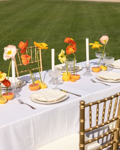 When @annapaulinephotography @stoddardfloralandco and I were designing this bridesmaids tablescape, we stumbled upon a floral design that had florals organically growing out of sunset colored fruit. The poppies were Anna’s favorite of the day and boy did they turn out incredibly beautiful! Do you like poppies in floral design? 😍 Photographer: @_ameysphotography Creative Director: @annapaulinephotography Planner: @bashboulevard Venue: @theantillamansion Florist: @stoddardfloralandco Hair... Orange Floral Tablescape, Fruit And Floral Tablescape, Summer Wedding Color Palette Bright, Colored Tablecloths Wedding, Poppy Themed Party, Sunset Flowers Wedding, Colorful Wedding Tablescape, Sunset Wedding Flowers, Sunset Theme Party