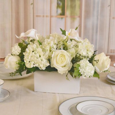 Enjoy lifelike beauty that lasts with our stunning, handcrafted floral arrangements. They effortlessly elevate your home décor with a touch of elegance and require no maintenance, staying vibrant year -round. | Primrue Mixed Centerpiece in Vase 11.0 H x 17.0 W x 11.0 D in greenFaux Silk in White | 11" H X 17" W X 11" D | Wayfair White Floral Centerpieces Long Table, Fall Flower Wedding Centerpieces, Basket Centerpieces Table Wedding, White Flower Arrangements Centerpieces, Round Floral Arrangements, All White Centerpieces, Simple Floral Centerpieces, Artificial Floral Centerpieces, Vase Candle Centerpiece