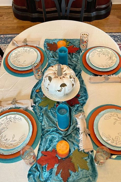 A simple Fall tablescape with a teal and orange color scheme. Simple centerpiece and place settings compliment the rest of the dining room fall decorations. Turquoise Thanksgiving Table, Teal And Orange Fall Decor, Family Reunion Ideas Organizing, Blue And Orange Fall Decor, Fall Tables, Orange Fall Decor, Simple Centerpiece, Thanksgiving Planning, Fall Decor Bedroom