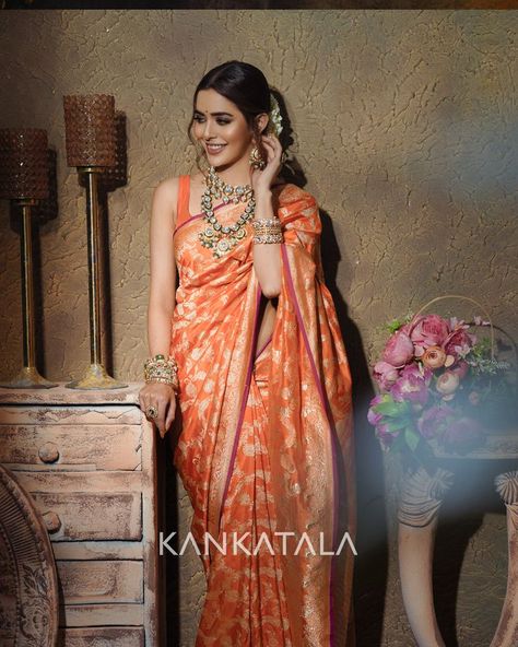 Sana Sayyad radiates in orange this saptami as she drapes herself in our handpicked Orange Banarasi Silk Jaal saree from Daivatvam Collection. The vibrant orange body of the handwoven silk is enamoured with gold zari kadwa jaal that Banarasis are known for. The self border features floral vines whereas the self pallu that sana flaunts glistens with gold zari brocade. #Daivatvam #9colorsofdivinity #mahagauri #festiveedition #navadurgaseries #weavesofindia #heritageweaves Banarasi Sarees Silk, Orange Benaras Saree, Orange Colour Pattu Saree, Benaras Silk Sarees, Orange Saree Look, Orange Bridal Saree, Orange Pattu Saree, Banarasi Silk Saree Bridal, Orange Colour Saree