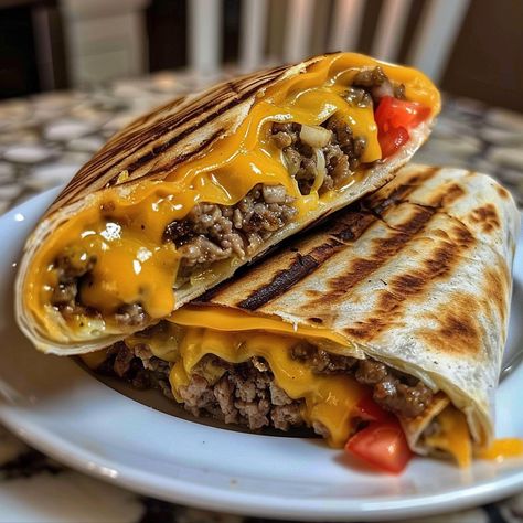 The Grilled Cheeseburger Wrap combines the classic flavors of a cheeseburger with the convenience of a wrap. It's a perfect fusion of two beloved dishes, offering a delightful twist on traditional fast food. This dish is not only easy to make but also customizable, allowing you to add your favorite toppings and sauces to suit...Read More Cheese Burger Wraps Ground Beef, Hamburger Wrap Recipes, Grilled Cheese Burger Wraps, Hamburger Sandwich Ideas, Wrap Burger Recipes, Cheese Burger Tortilla Wraps, Grilled Cheeseburger Wraps, Burger In Tortilla Wrap, Bacon Cheeseburger Wraps