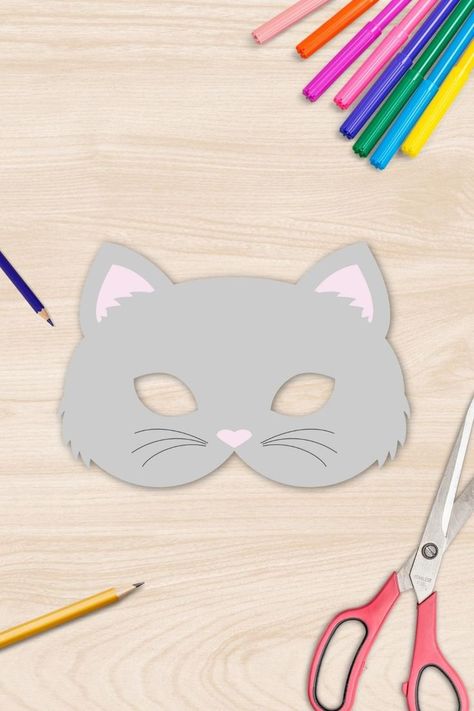 A cat mask made out of paper laying on a table surrounded by pens and scissors. Cat Mask Template Free Printable, Cat Mask Template, Halloween Mask Printable, Cat Masquerade Mask, Cat Mask Diy, Cat Costume Diy, Coloring Mask, Mask Printable, Make Your Own Paper