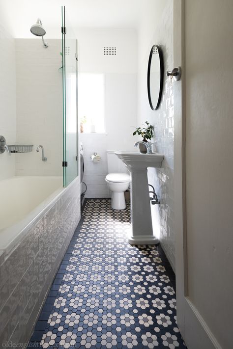 This light-filled bathroom harks back to the aesthetically lavish era of the roaring Art Deco years. A delicately ornate mosaic feature floor, coupled with an organic-edge wall tile, ceremoniously marries heritage pizzazz with modern cleanliness, for a fresh, character-filled finish. Tile Arrangement, Geometric Tiles Bathroom, Mosaic Bathroom Floor, Traditional Bathroom Tile, Mosaic Floor Tiles, Bathroom Upstairs, Heritage Bathroom, Vintage Bathroom Tile, Laundry Room Lighting