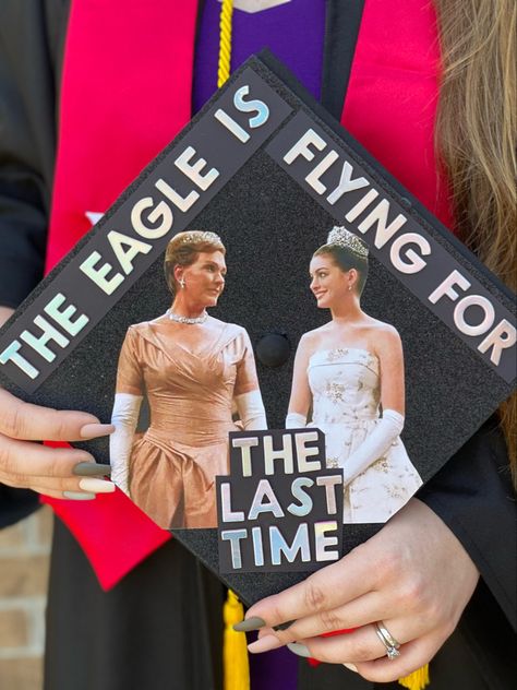 The picture is of a graduation cap that says “the eagle is flying for the last time” which is a quote from the movie. It has colored pictures of the queen and princess of Ginovia from the movie, The Princess Diaries. She Doesn’t Even Go Here Graduation Cap, Cars Movie Graduation Cap, Princess Diaries Grad Cap, Starry Night Graduation Cap, Grad Cap Ideas College First Generation, Graduation Cap Designs Disney Princess, New Girl Graduation Cap, College Grad Caps Ideas, 10 Things I Hate About You Grad Cap