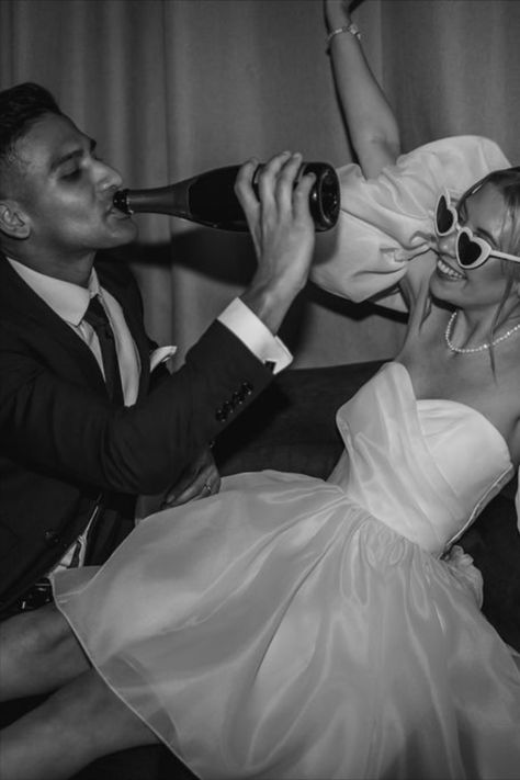 Bride in puff sleeve short wedding reception dress with retro wedding sunglasses celebrating with the groom drinking champagne from the bottle | wedding day | disco wedding | retro sunglasses | short wedding dress | reception wedding dress | wedding drinks | Lindsey Ria Photography Sunglasses With Wedding Dress, Short Wedding Dress Photoshoot, Short Wedding Dress Sunglasses, After Party Photoshoot, Bride And Groom Sunglasses, Bride Sunglasses Wedding, Retro Wedding Photoshoot, Retro Wedding Reception, Short Wedding Reception Dress