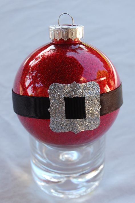 Santa-belt ornament (I've made 10 of these): I decorated clear plastic ornament with Pledge floor wax and Martha Stewart glitter.  I adorned them with black grosgrain ribbon and silver buckle (that I punched out of a duck-tape roll). Plastic Christmas Ornaments, Clear Plastic Ornaments, Clear Christmas Ornaments, Disney Christmas Decorations, Idee Cricut, Diy Christmas Tree Ornaments, Clear Ornaments, Handmade Christmas Crafts, Christmas Ornaments Homemade