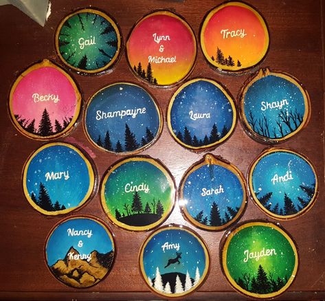 Wood slices painted with sceneries and monogrammed with family members names Name Tag Ideas, Wood Cookies, Whimsical Cottage, Camp Vibes, Ornament Cookies, Christmas Ornament Ideas, Wooden Slices, Scenery Paintings, Family Christmas Ornaments