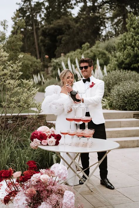 Red and pink wedding theme at Middleton Lodge. The bride wears a Chosen by Kyha dress with puff sleeves adorned with pearls and Chanel shoes. Pink And Red Wedding Groomsmen, Light Pink And Red Wedding, Cherry Wedding Theme, Red Pink And Black Wedding, Pink Red Wedding Theme, Pink And Red Bridesmaid Dresses, Cherry Red Wedding, Pink And Red Wedding Theme, Wedding Bouquet With Pearls