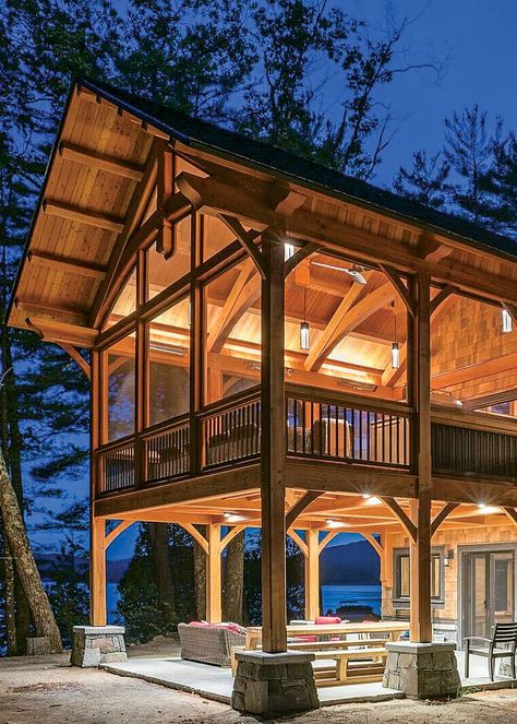 Twice the fun — this elevated screened porch allows for an open patio below, providing two outdoor entertainment options to choose from. Both spaces feature elegant timber frame details and abundant lighting, which also accentuates the home’s exceptional craftsmanship. Casa Hobbit, Haus Am See, Lots Of Windows, Screen Porch, Rustic Home Design, Metal Screen, Pole Barn Homes, Barn House Plans, Screened In Porch