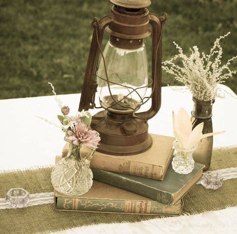 Centerpiece vintage More Vintage Lanterns Rustic, Oil Lanterns Wedding Centerpieces, Enchanted Wedding Reception Decor, Antique Lantern Centerpieces, Vintage Lantern Wedding Decor, Vintage Lantern Centerpieces, Old Books Wedding Decor, Antique Wedding Centerpieces, Vintage Antique Wedding Decor