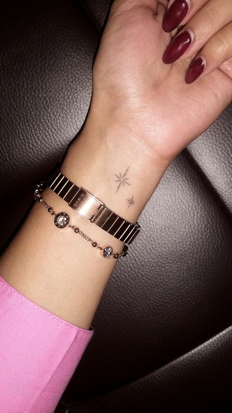 Wrist is shown with a rose gold bracelet and watch, and a tattoo of two little sparkles. Hand Tattoos Sparkles, Sparkles Tattoo, Tattoos On Arm, Sparkle Tattoo, Small Star Tattoos, Baby Tattoo Designs, Baby Tattoo, Arm Tats, M Tattoos